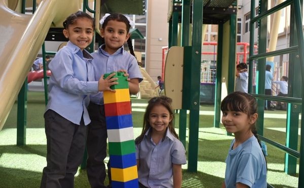 Kindergarten students at AIS, one of the top Abu Dhabi schools, playing in a playground