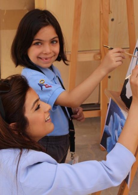 A parent of AIS, one of the best private schools in Abu Dhabi, painting a canvas with her daughter