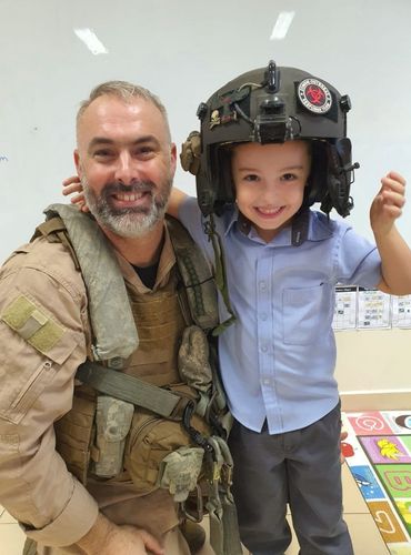 A parent of AIS, one of the best private schools in Abu Dhabi, posing with his son in an Army uniform