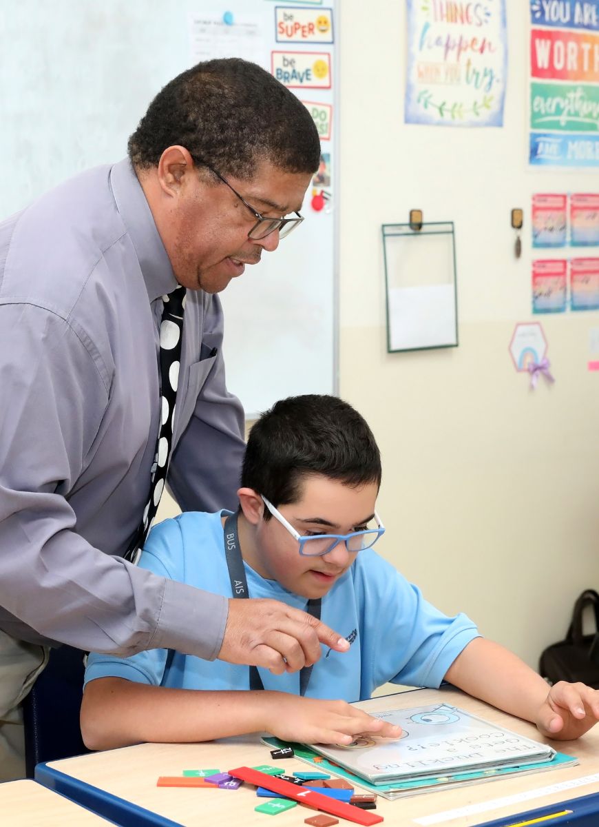 A teacher at Abu Dhabi International School assisting a student with special needs