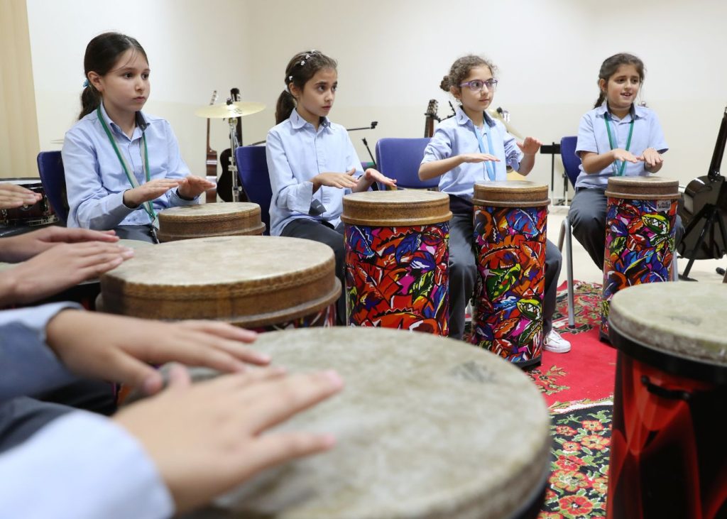 Students of AIS, one of the top secondary schools in Abu Dhabi, learning instruments in the music room